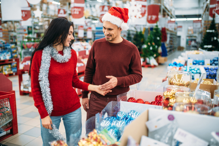 Young couple chooses christmas tree toys in shopの写真素材