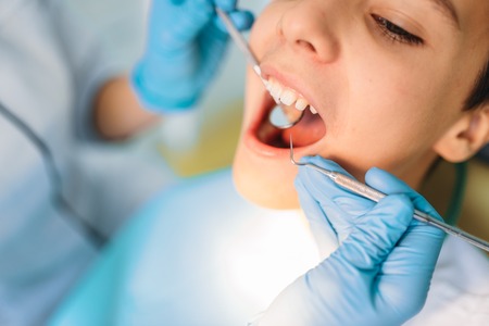 Little boy with open mouth in a dental cabinetの写真素材