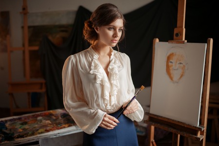 Painter drawing with color palette and brushの写真素材