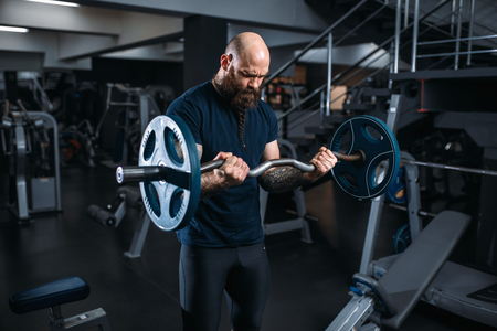 Muscular athlete doing exercise with barbellの写真素材