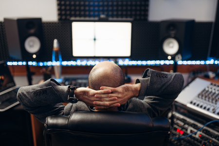 Male sound engineer at remote control, back viewの写真素材