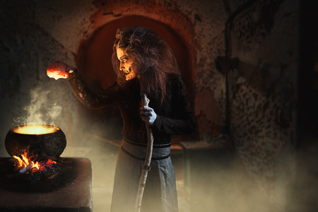 Witch reads spell over pot with human body partsの写真素材