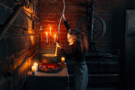 Scary witch cooking soup and reads spellの写真素材