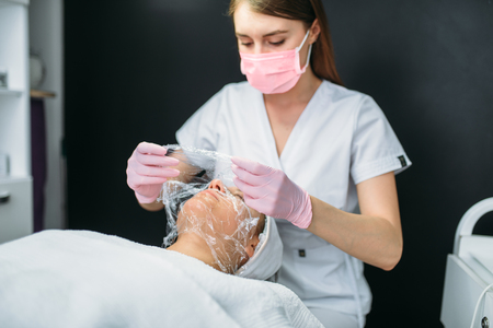 Doctor makes face mask, getting rid of wrinklesの写真素材