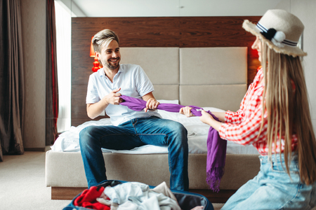 Playful couple prepares baggage, fees on journeyの写真素材