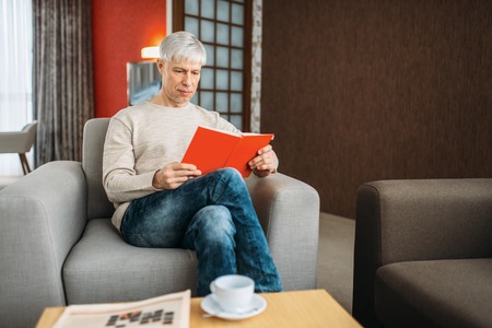 Adult man with notebook sitting on couch at home