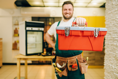 Repairman in uniform holds toolbox, handymanの写真素材