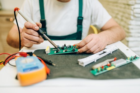 Repairman fixing problem with refrigerator at homeの写真素材