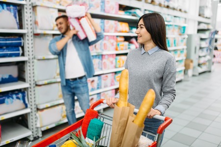 Couple buying a lot of diapers in supermarketの写真素材