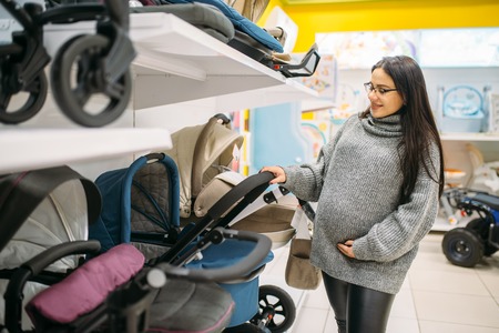 Pregnant woman in shop of goods for newborns