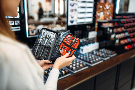 Customer choosing cosmetics tools in makeup shopの写真素材