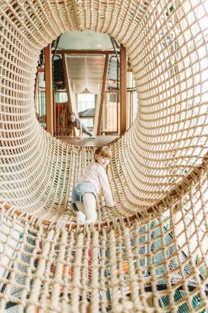 Two girls plays in rope net, children game centerの写真素材