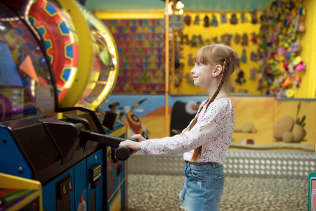 Little girl plays game machine, children centerの写真素材
