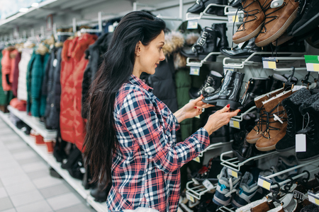 Young woman choosing shoes in supermarketの写真素材