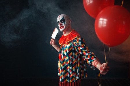 Bloody clown with meat cleaver holds air balloonの写真素材