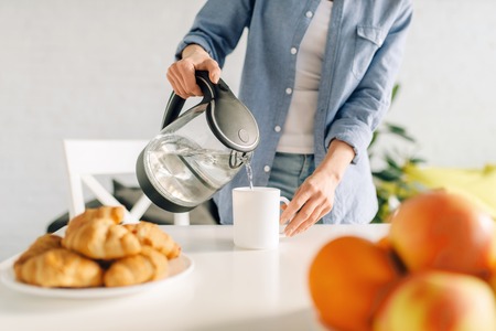 Happy woman cooking breakfast on the kitchenの写真素材