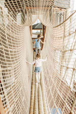 Two girls plays in rope net, children game centerの写真素材