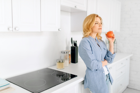 Woman poses on kitchen with snow-white interiorの写真素材