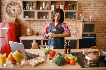 Black woman in apron cooking healthy breakfastの写真素材