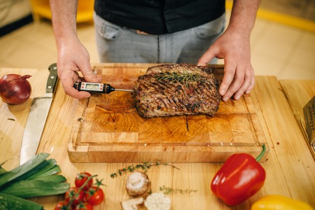 Chef at the pan with roasted meat and vetablesの写真素材