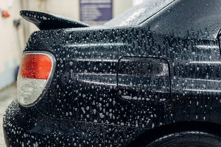 Carwash service, car in foam, side viewの写真素材