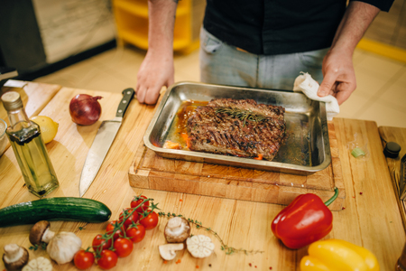 Chef at the pan with roasted meat and vetablesの写真素材