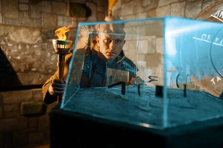Ancient traveler with torch at the glass puzzle