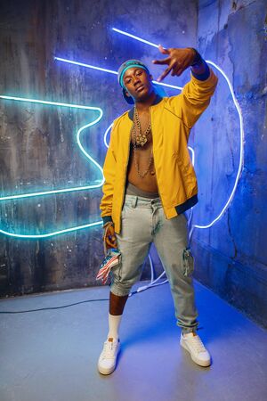 Black rapper in underpass neon light on backgroundの写真素材