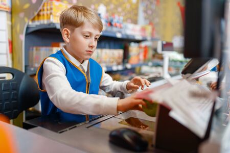 Boy in uniform at the register playing salesman