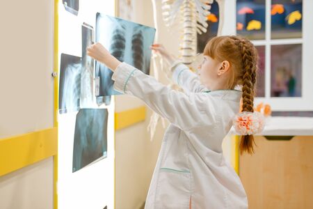 Little girl in uniform looks at the x-ray, doctorの写真素材