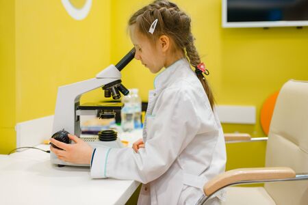 Girl at the microscope, playing doctor, playroomの写真素材
