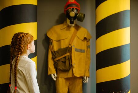Female child looks on fireman mannequin, playroomの写真素材