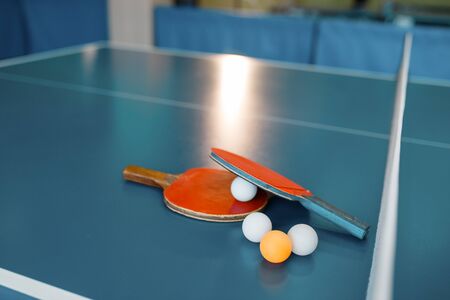 rackets and balls on game table with netの写真素材