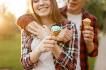 Young love couple with ice cream in summer park