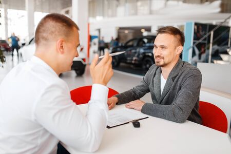 Manager and buyer make out the purchase of new carの写真素材