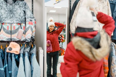 Woman at the showcase choosing ski suit, shoppingの写真素材