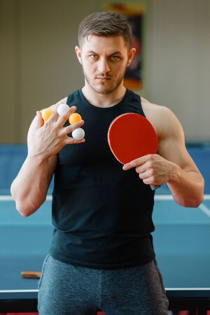 Man holds table tennis balls between fingers