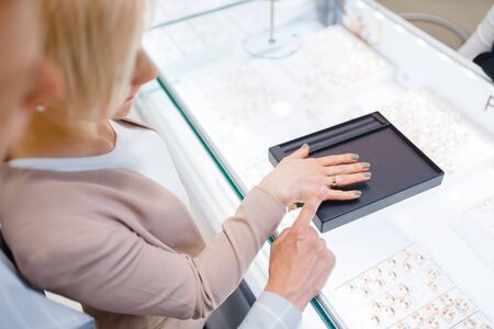Couple in jewelry store, bride trying on ringの写真素材
