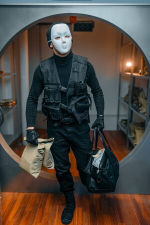 Bank robbery, robber in black uniform and mask