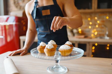 Nude husband in apron cooking dessert with creamの写真素材