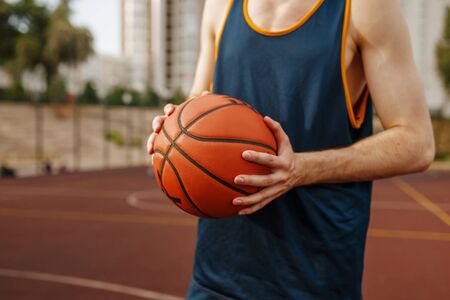 Basketball player aiming for throw, outdoor courtの写真素材