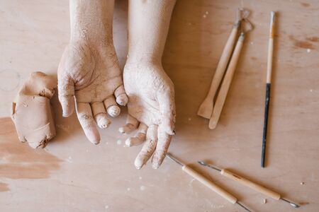 Female potter hands covered with dried clayの写真素材
