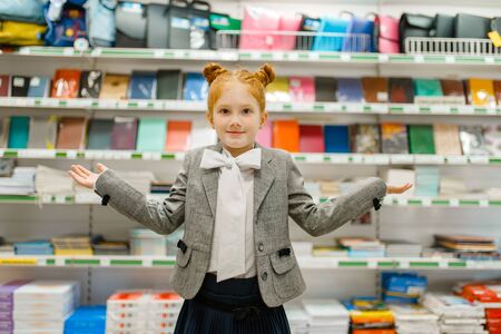 Girl at the shelf in stationery store, front view