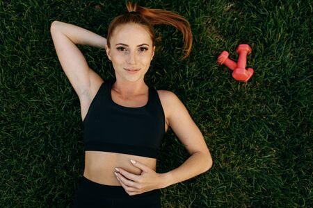 Female runner lying on the grass, top viewの写真素材