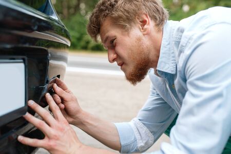Car breakdown, young man screwed in towing hookの写真素材