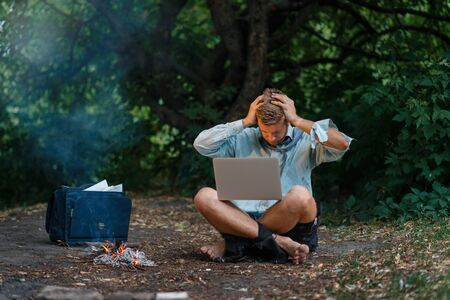 Alone businessman with laptop at fireplace, islandの写真素材