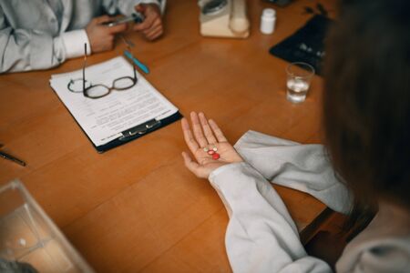 Psychiatrist gives sedative pill to female patientの写真素材