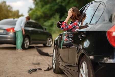 Male and female drivers after car accident on roadの写真素材