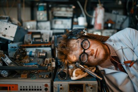 Strange engineer sleeping on devices in labの写真素材