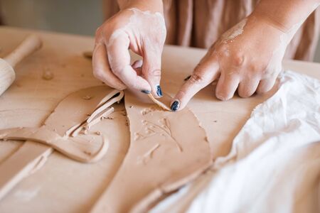 Female potter shaping clay, pottery workshopの写真素材